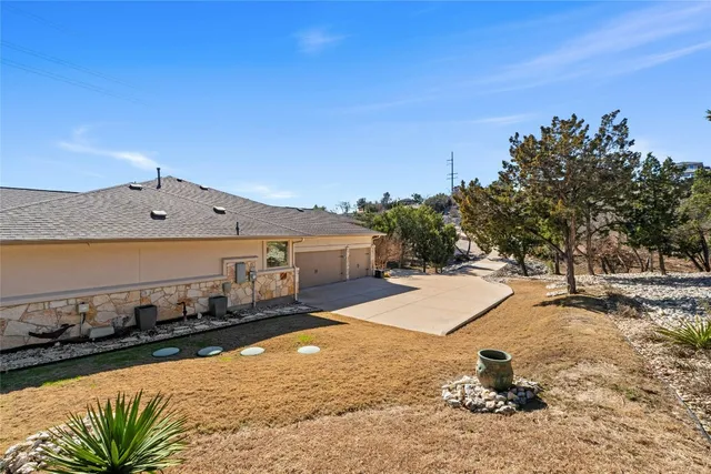 a view of a white house with a large tree