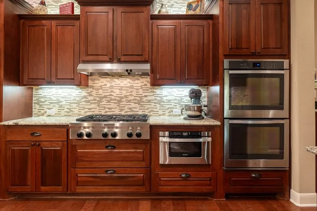 a kitchen with granite countertop wooden cabinets and stainless steel appliances
