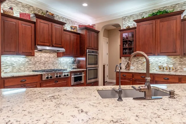 a kitchen with stainless steel appliances granite countertop a refrigerator stove and sink