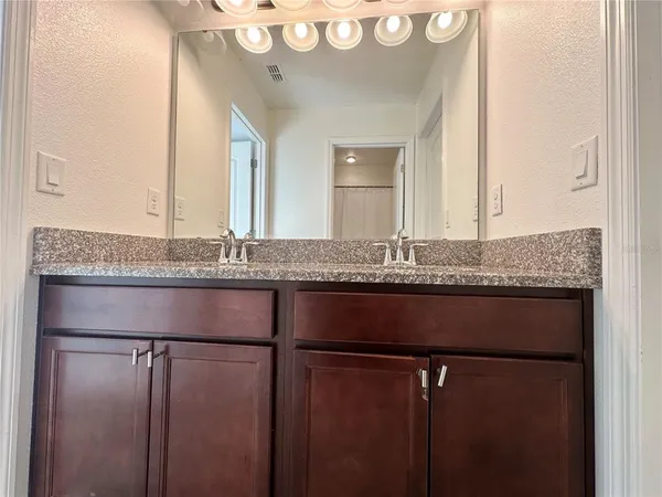 a bathroom with a granite countertop sink and a mirror