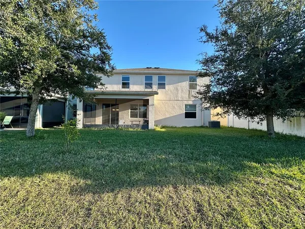 a view of a yard in front of a house with a large tree