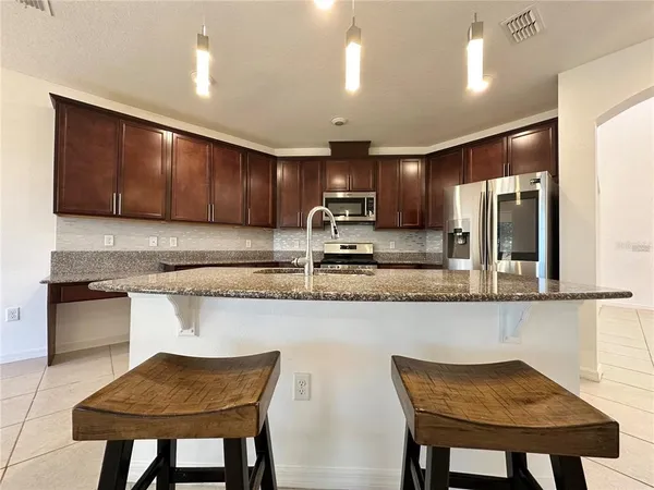 a kitchen with kitchen island granite countertop wooden cabinets and a granite counter tops