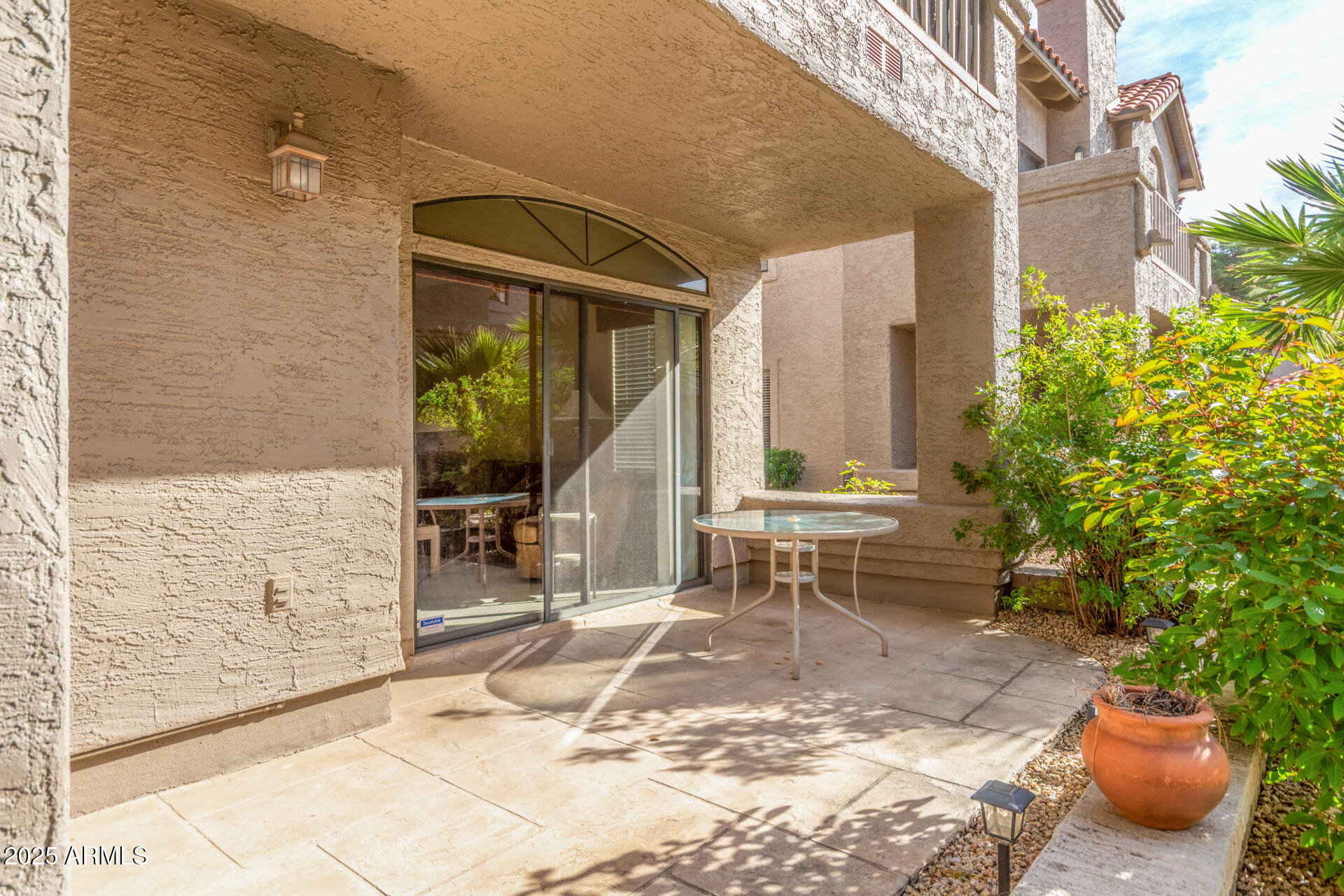 10019 East Mountain View Road, Unit 1121 Scottsdale, AZ 85258 - Photo 27 of 39 a view of a patio with table and chairs potted plants and floor to ceiling window