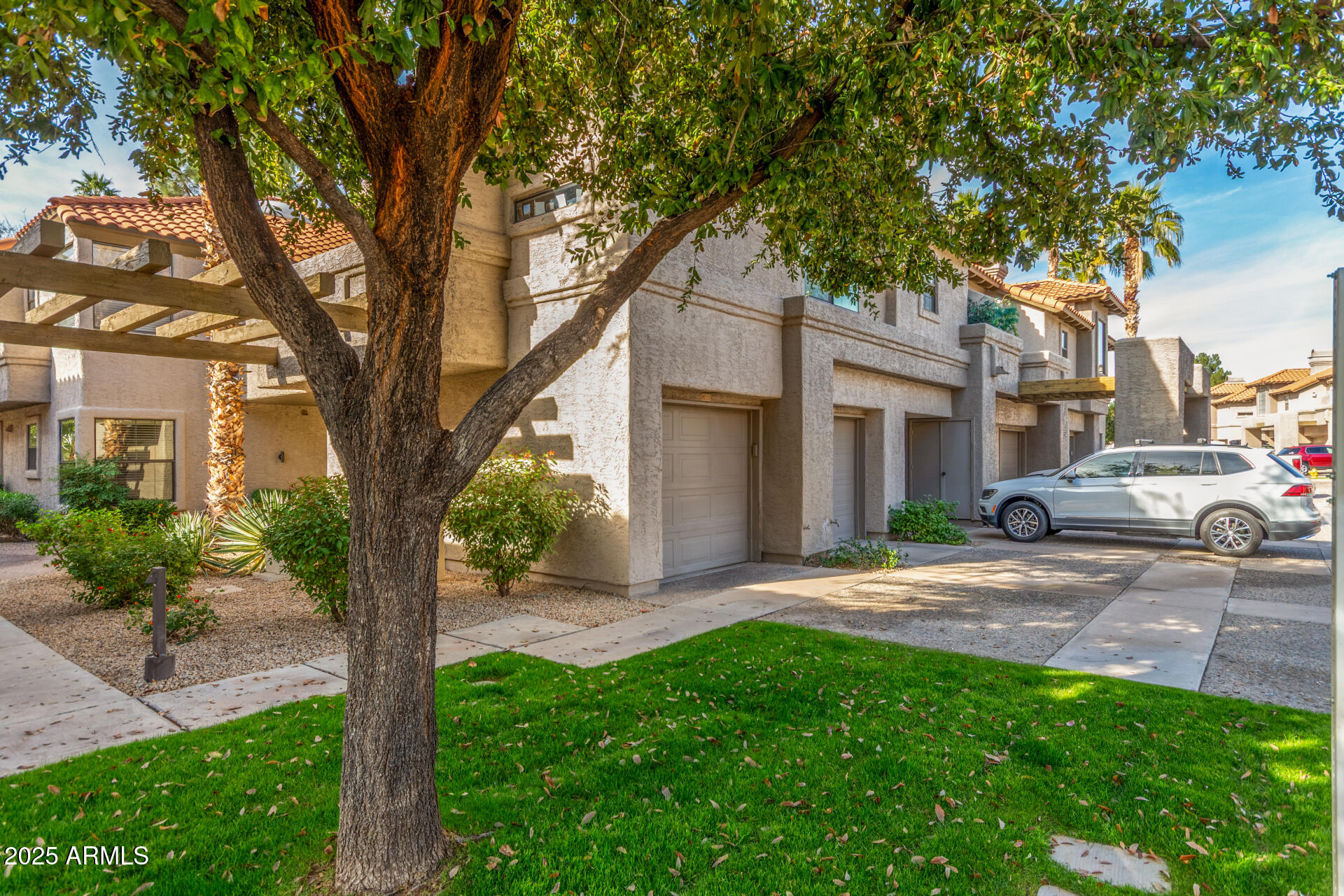 10019 East Mountain View Road, Unit 1121 Scottsdale, AZ 85258 - Photo 38 of 39 a view of a yard in front of a house with a large tree