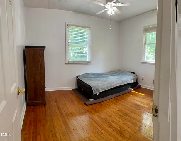 a bedroom with a bed and wooden floor