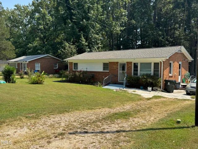 a front view of a house with a yard and trees