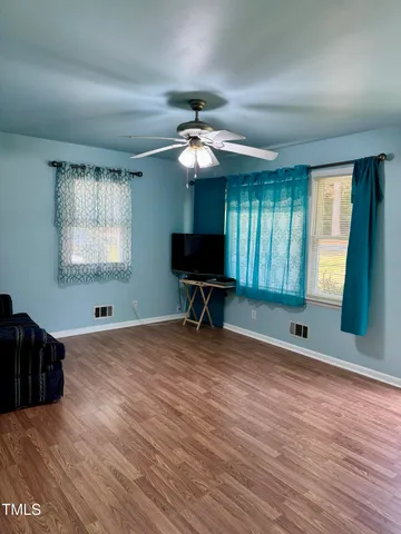 a living room with furniture and a ceiling fan