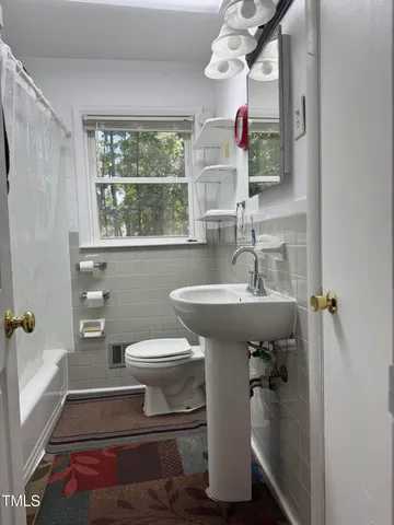 a bathroom with a sink toilet and a mirror