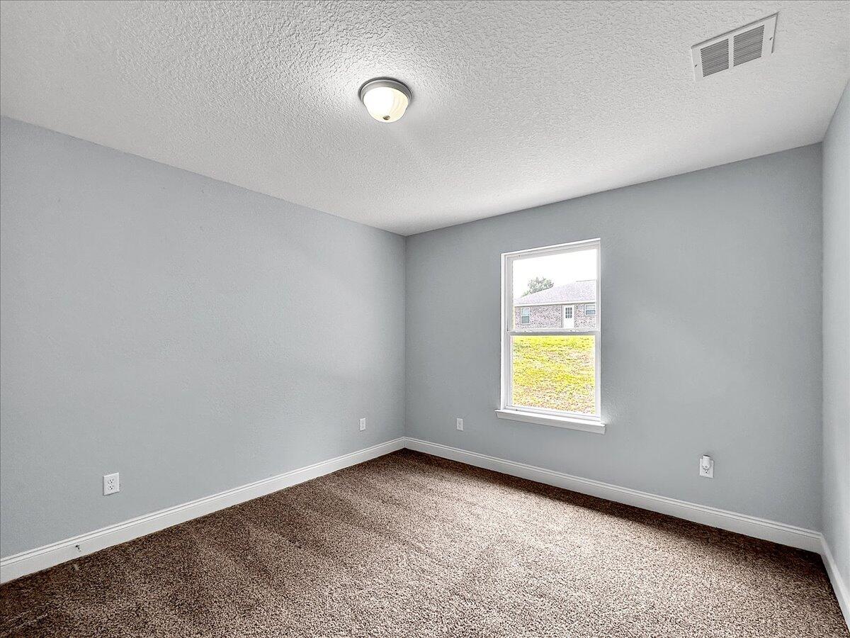2970 Stillwell Boulevard Crestview, FL 32539 - Photo 13 of 20 a view of an empty room with a window and a kitchen