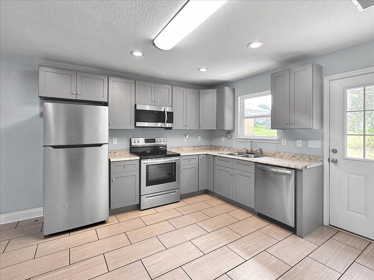 2970 Stillwell Boulevard Crestview, FL 32539 - Photo 4 of 20 a kitchen with granite countertop cabinets and steel stainless steel appliances