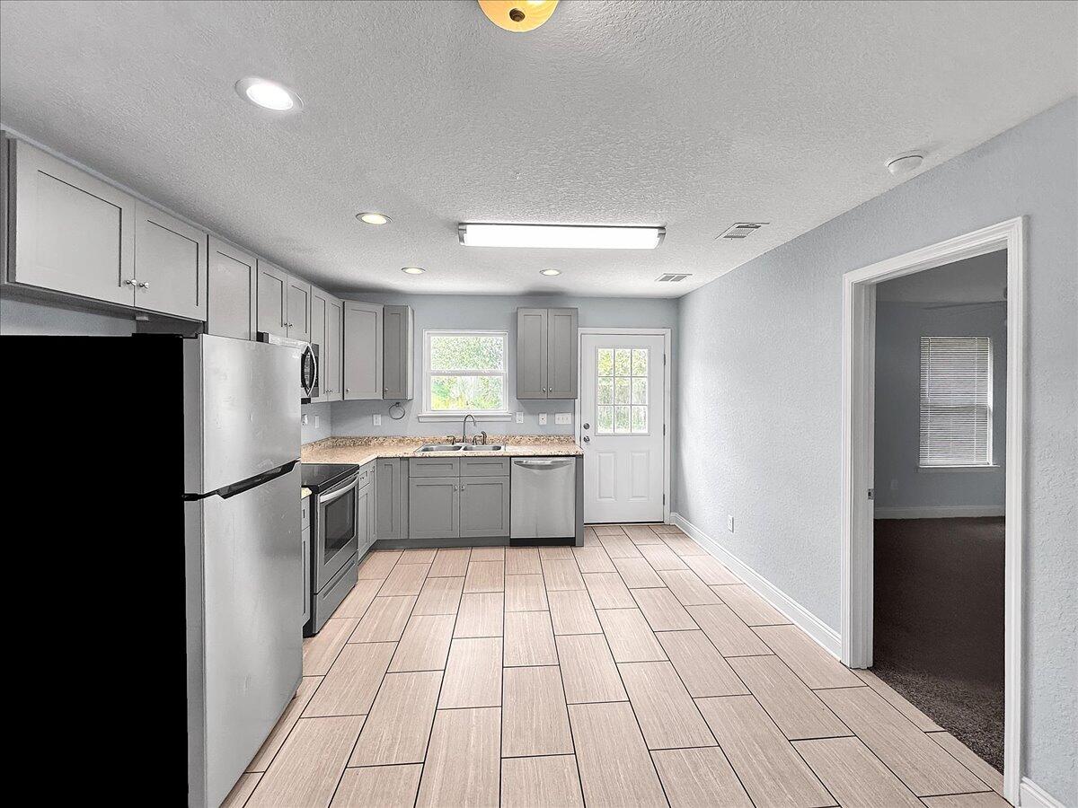 2970 Stillwell Boulevard Crestview, FL 32539 - Photo 9 of 20 a kitchen with a refrigerator a sink and cabinets