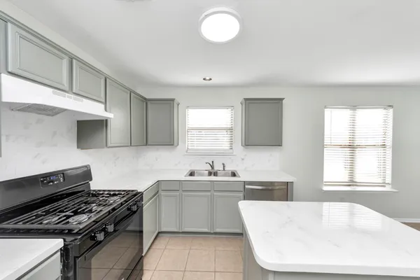 a kitchen with a sink stove and cabinets