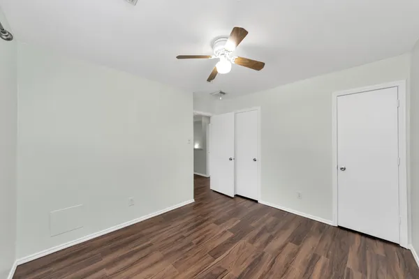 a view of a room with wooden floor and ceiling fan