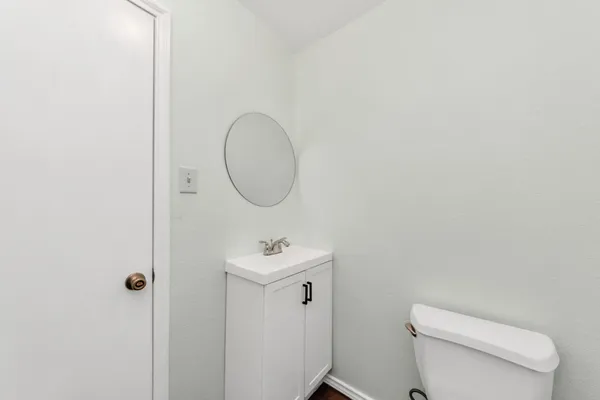 a bathroom with a toilet a sink and mirror