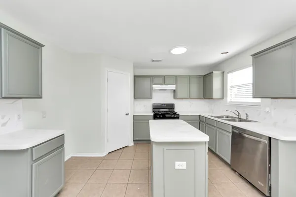 a kitchen with a sink a stove and cabinets
