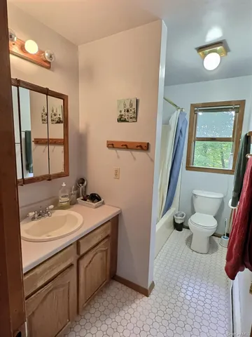 a bathroom with a granite countertop sink toilet and mirror