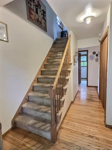 a view of staircase with wooden floor and white walls