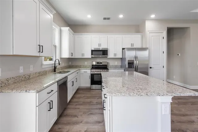 a bathroom with a granite countertop sink a toilet and shower