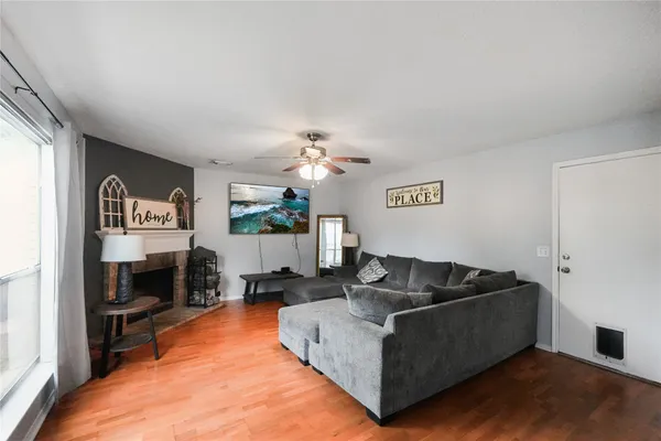 a view of a room with wooden floor and a ceiling fan