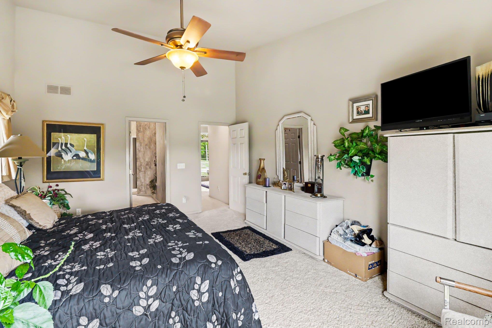 18501 Taylor Lake Road Holly, MI 48442 - Photo 18 of 35 Spacious room featuring vaulted ceilings, a ceiling fan with integrated lighting, and plush carpeting