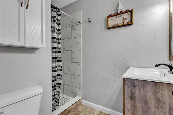 a bathroom with a shower toilet and sink