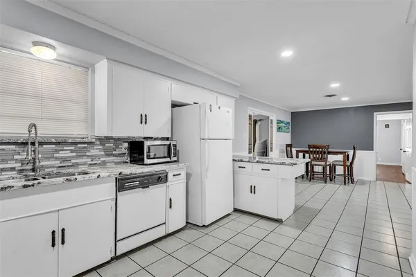a kitchen with white cabinets and white appliances