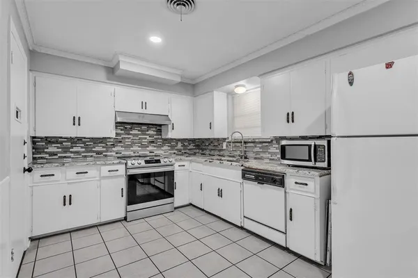 a kitchen with granite countertop white cabinets and white appliances