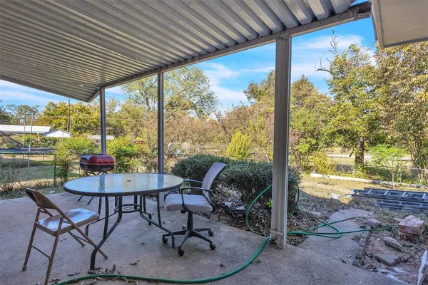 a view of a porch with furniture and a yard