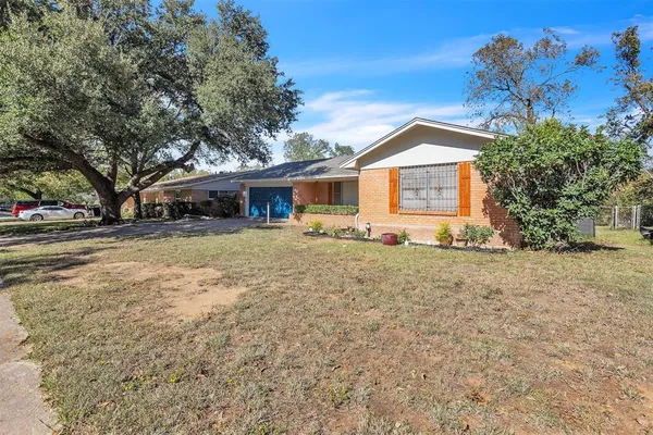 a front view of house with yard and trees around
