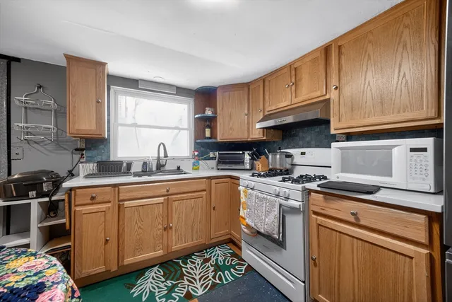 a kitchen with stainless steel appliances granite countertop a sink stove and cabinets
