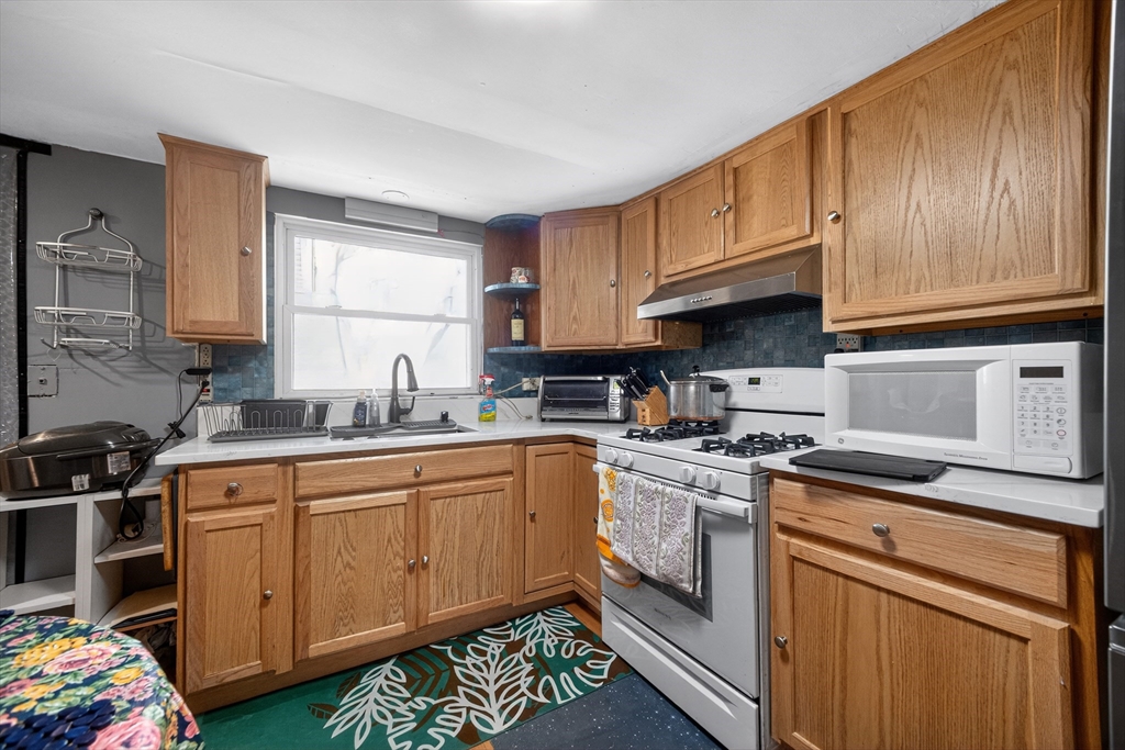 5 South Webster Street Haverhill, MA 01835 - Photo 6 of 15 a kitchen with stainless steel appliances granite countertop a sink stove and cabinets