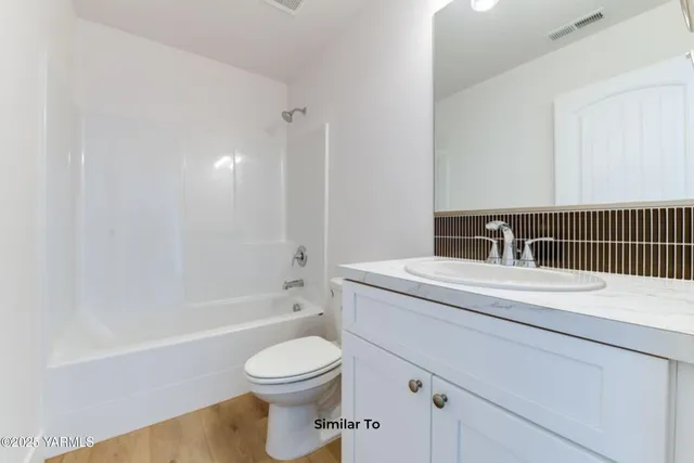 a bathroom with a sink toilet vanity and shower