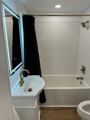 a bathroom with a sink a toilet and shower