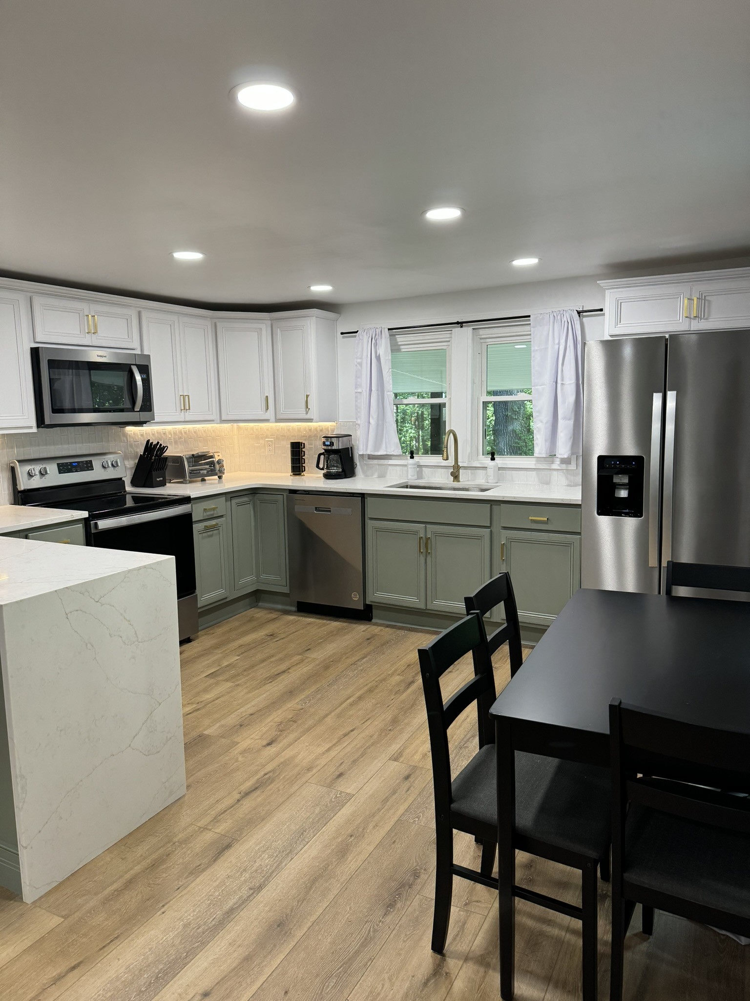 710 3rd Street Paris, TN 38242 - Photo 21 of 34 a kitchen with stainless steel appliances granite countertop a stove a sink a microwave refrigerator and chairs