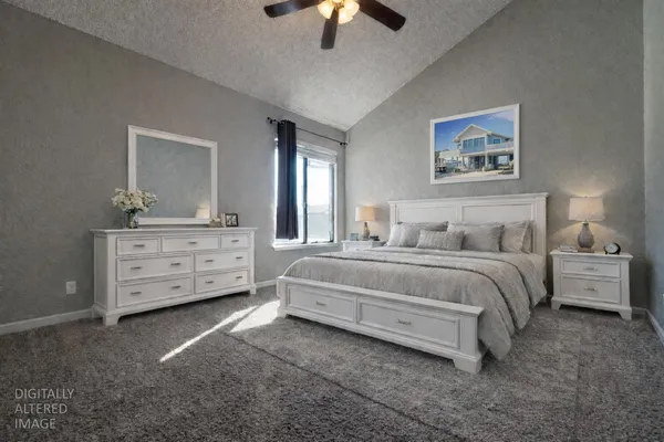 a spacious bedroom with a bed and a lamp on dresser
