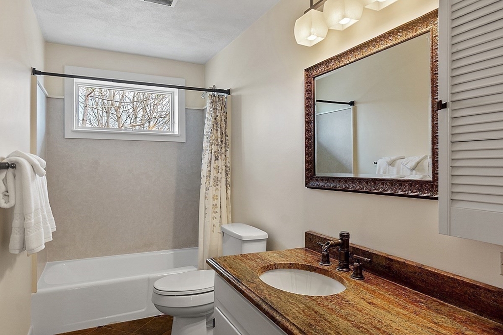 39 Decatur Street, Unit WINTER Gloucester, MA 01930 - Photo 19 of 38 a bath room with a toilet a sink and a mirror