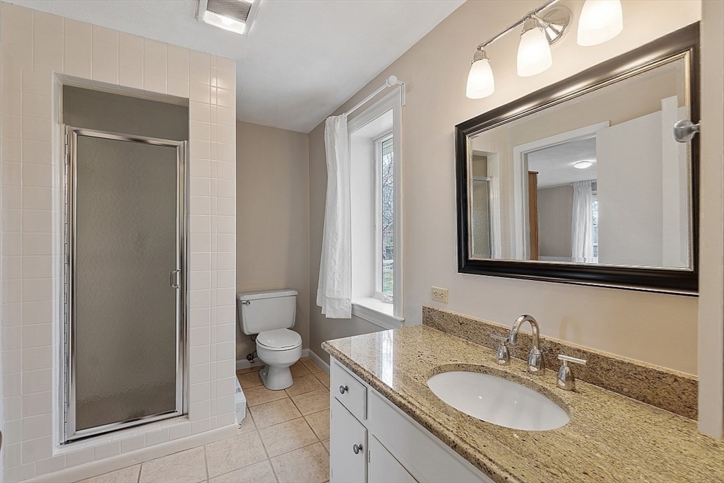 39 Decatur Street, Unit WINTER Gloucester, MA 01930 - Photo 23 of 38 a bathroom with a granite countertop sink toilet and mirror