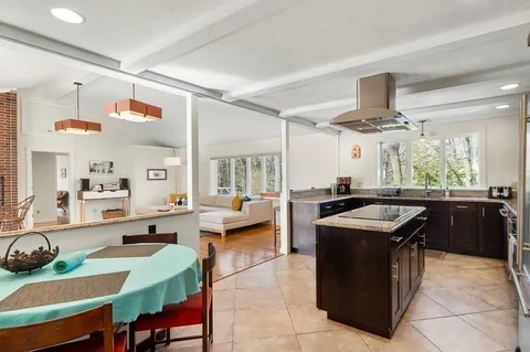 a kitchen with a stove kitchen island and couches with wooden floor
