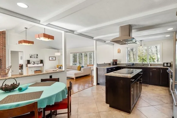 a kitchen with a stove kitchen island and couches with wooden floor