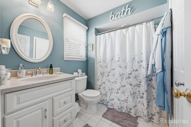 a bathroom with a granite countertop sink a toilet and a mirror