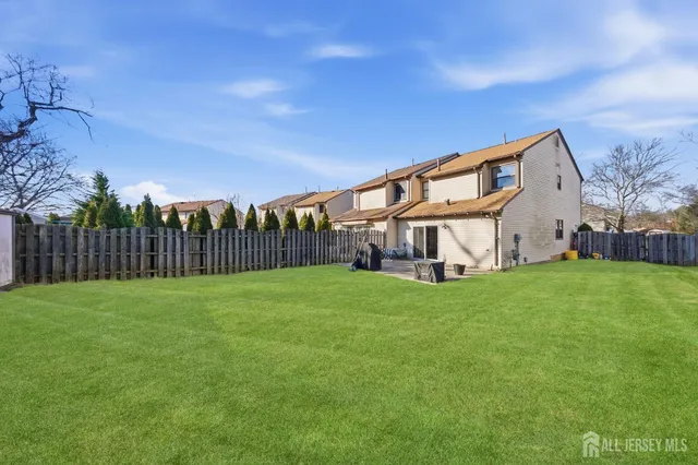 a view of a big house with a big yard plants and large trees