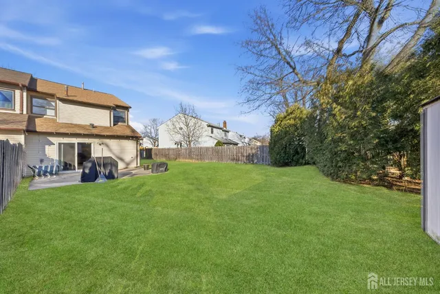 a view of a yard with table and chairs and large trees