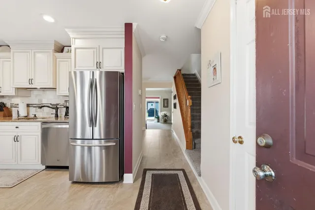 a view of a kitchen with refrigerator and wooden floor
