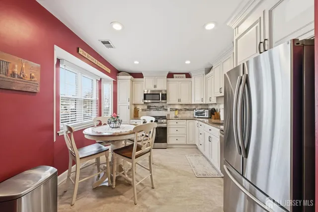 a kitchen with refrigerator cabinets dining table and chairs