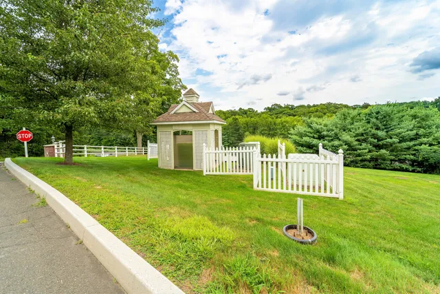 a view of a house with a yard and fence