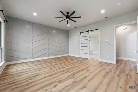 an empty room with wooden floor and windows