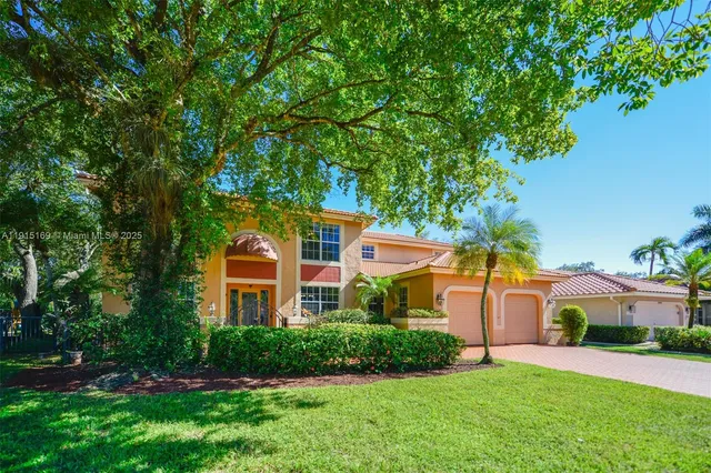 a front view of a house with a yard and trees