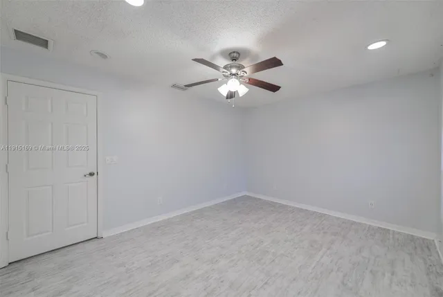 a view of an empty room with a ceiling fan and a window