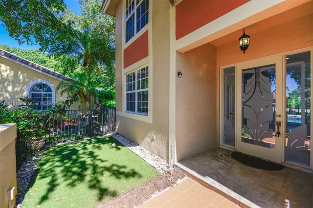 a front view of a house with a yard and potted plants