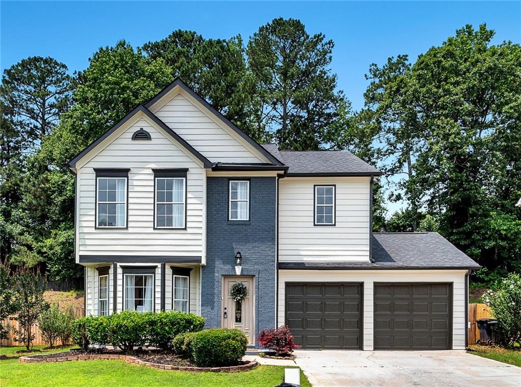 a front view of a house with a yard and garage